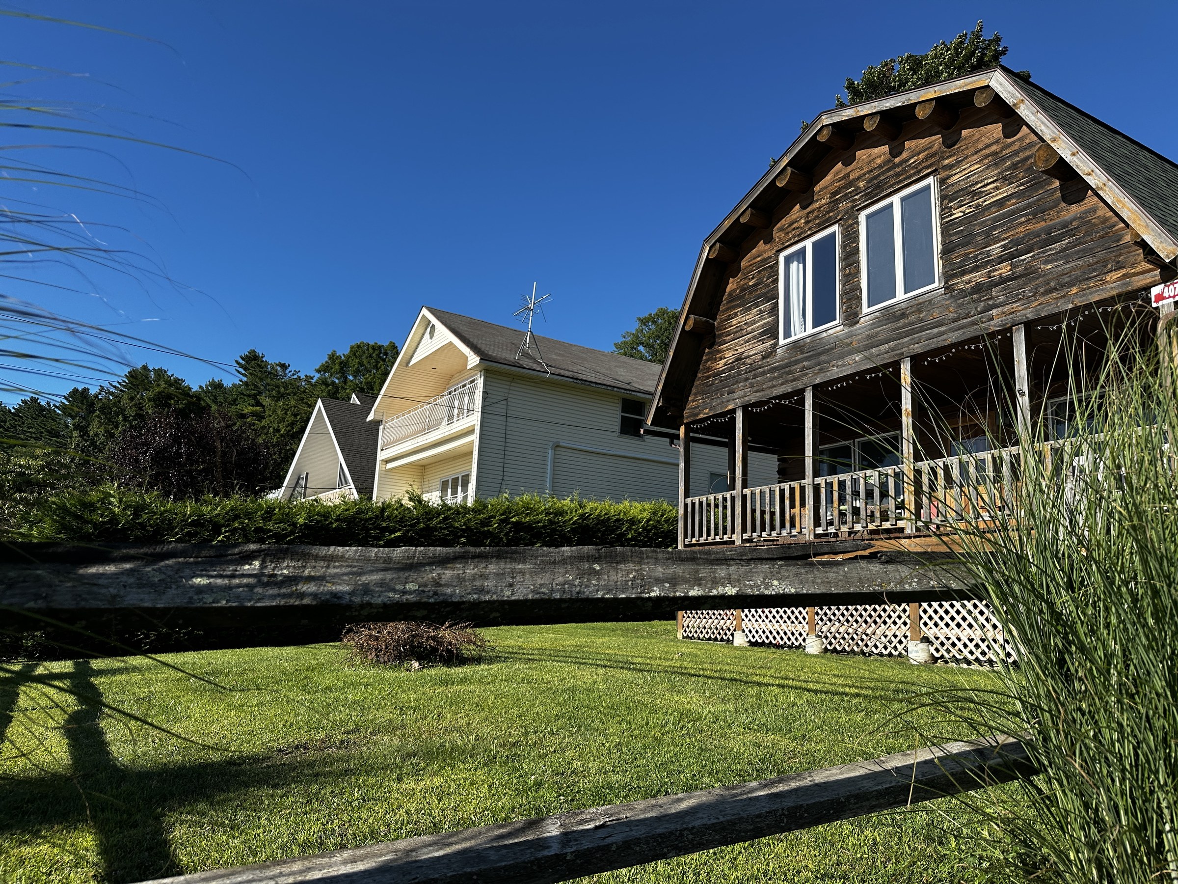 A group of upstate homes beneath a deep blue summer sky